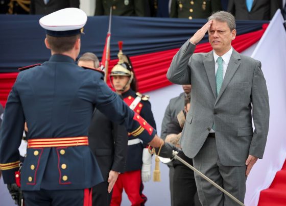 Foto colorida de Tarcísio de Freitas prestando continência em solenidade militar